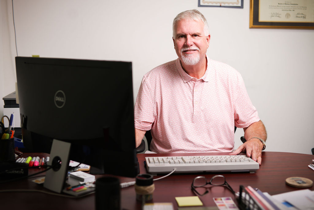 Chris Cawthon sitting at ABC Direct Marketing office desk